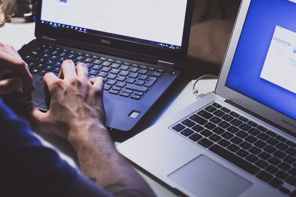 Person working with multiple computers for different employers